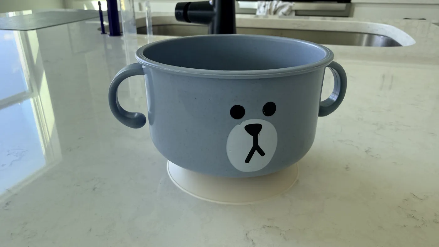 The blue bear bowl on a kitchen counter with its pale suction base fitted underneath